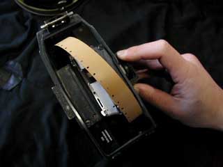 ギアに噛んだ手ごたえを感じたら、さらにギアを送ります。この時注意する事は、ギアに噛ませようとした時に、先程の白い線に合わせてとったフィルムの長さが変わってしまっていることがあることです。この、ループの長さをきめる作業とギアに噛ませる作業を往復し、確認しながら作業を進めて下さい。