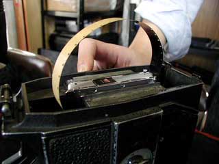 フィルムの端を留めているテープを手探りで探し、剥がします。