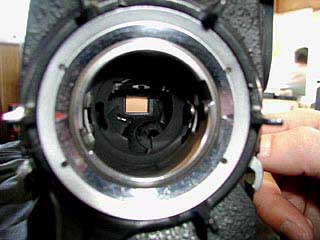 ライト付きのルーペを使って、フィルムの見えている窓の周りにゴミが付着していないか調べます